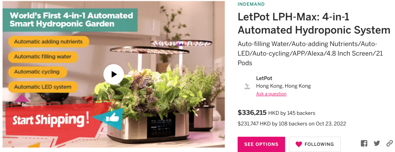 Automated indoor hydroponic garden system with LED grow lights and lush green plants on a kitchen counter.